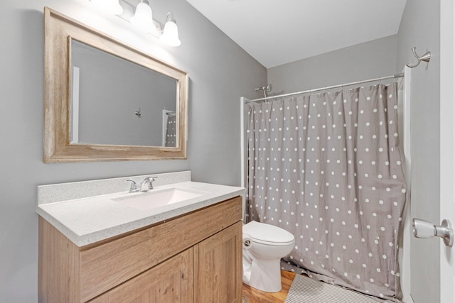 full bathroom with curtained shower, toilet, vanity, and wood finished floors