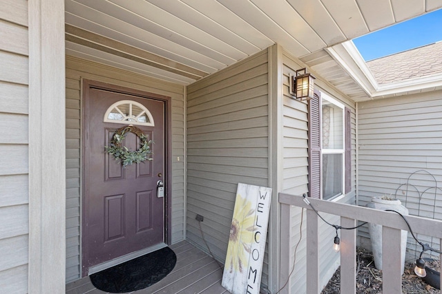 property entrance featuring a shingled roof