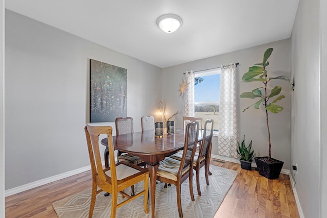 dining space featuring visible vents, baseboards, and light wood finished floors