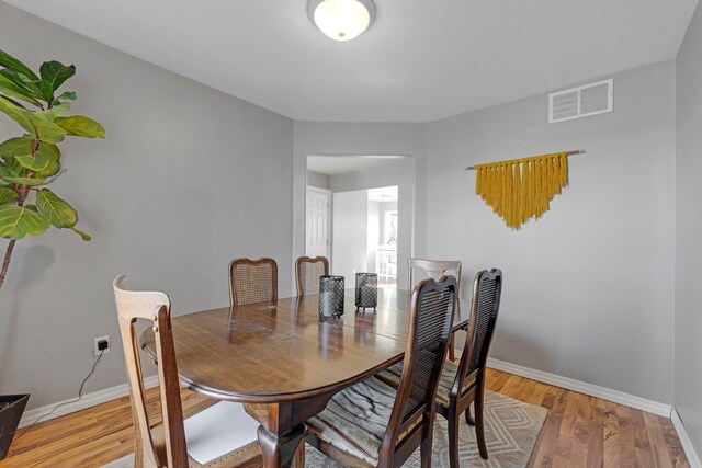 dining space featuring visible vents, baseboards, and light wood finished floors