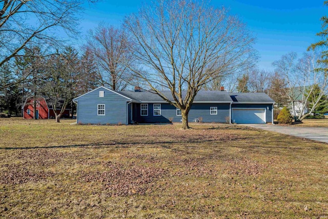 ranch-style house featuring a front lawn, a garage, driveway, and a chimney