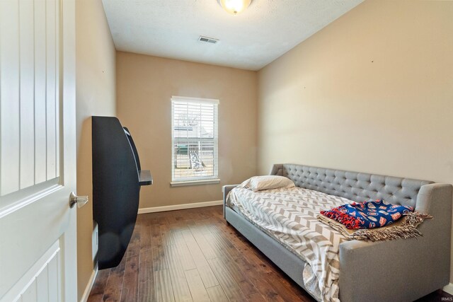 bedroom with visible vents, baseboards, and wood-type flooring