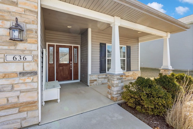 property entrance with stone siding and a porch