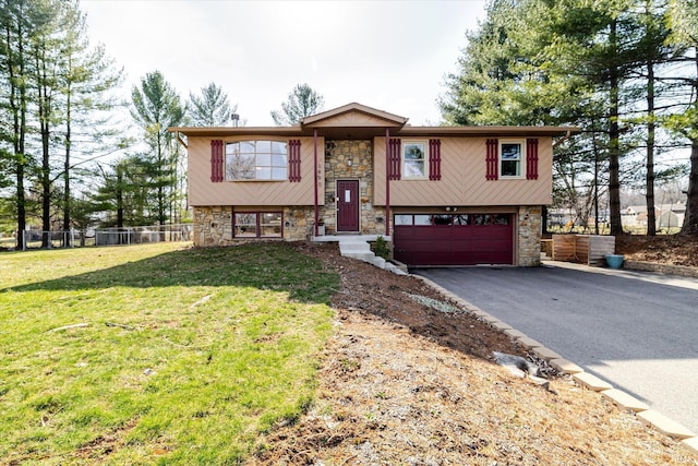 bi-level home featuring a garage, stone siding, a front lawn, and driveway