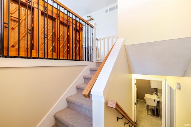 stairs featuring visible vents and vaulted ceiling