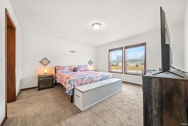 bedroom featuring light colored carpet and baseboards