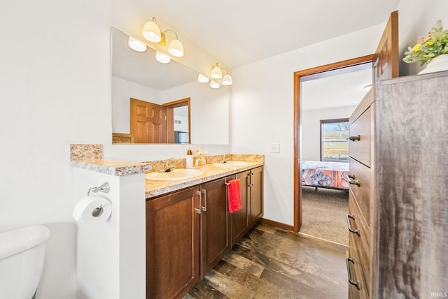 ensuite bathroom featuring a sink, toilet, ensuite bath, and double vanity