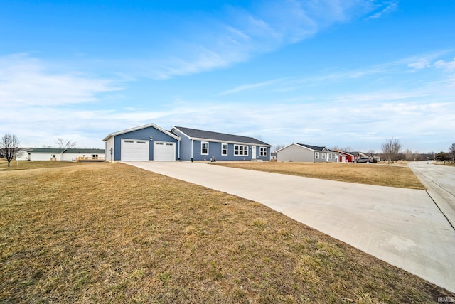 ranch-style house featuring a front yard, concrete driveway, and an attached garage