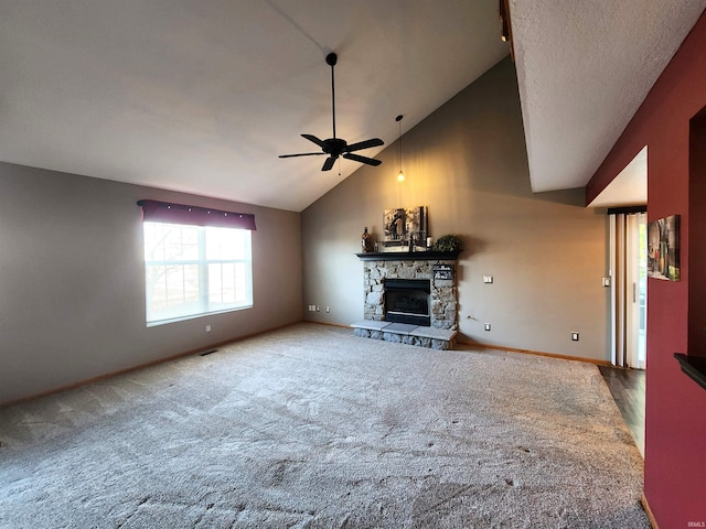 unfurnished living room featuring visible vents, baseboards, ceiling fan, a stone fireplace, and high vaulted ceiling