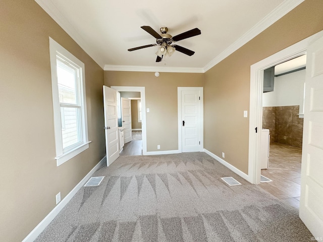 unfurnished bedroom featuring visible vents, baseboards, light colored carpet, and crown molding