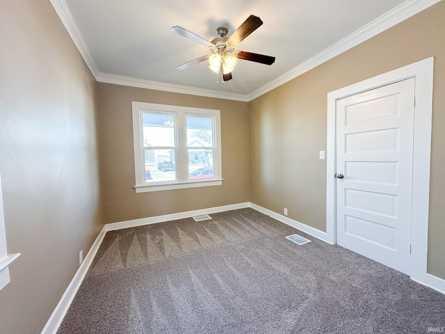 empty room featuring visible vents, crown molding, and baseboards