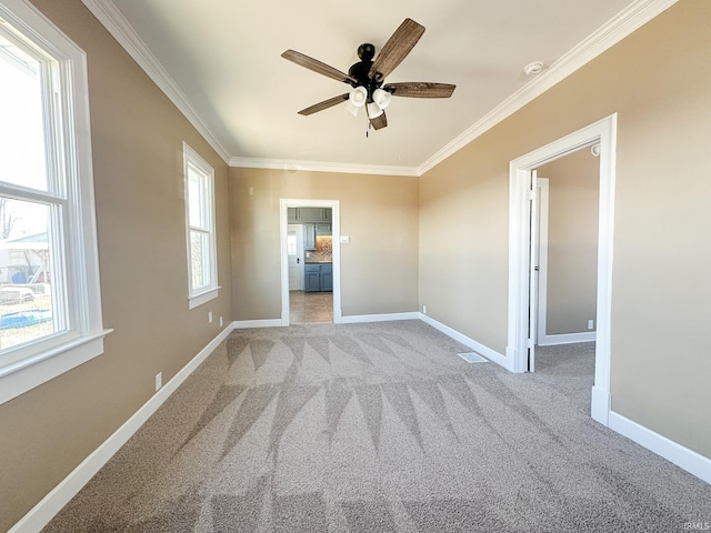 unfurnished bedroom with crown molding, light colored carpet, baseboards, and visible vents