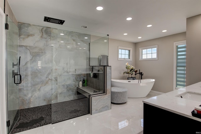 bathroom featuring a marble finish shower, a soaking tub, recessed lighting, and vanity