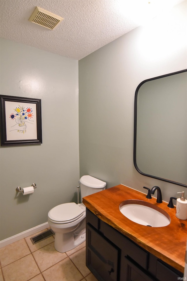 half bath featuring tile patterned flooring, visible vents, a textured ceiling, and toilet