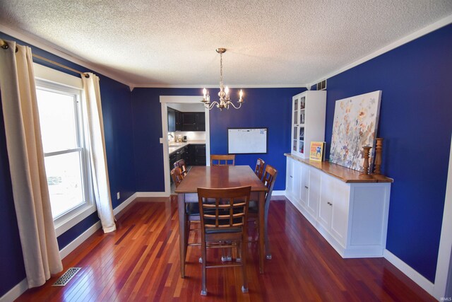 dining room with a notable chandelier, visible vents, baseboards, and dark wood-style flooring