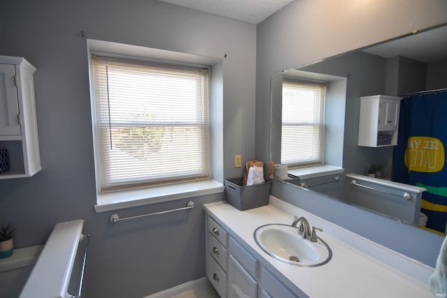 bathroom featuring vanity, a shower with curtain, baseboards, and a textured ceiling