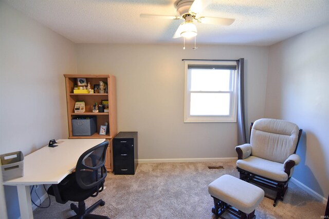 home office with baseboards, light carpet, a textured ceiling, and a ceiling fan