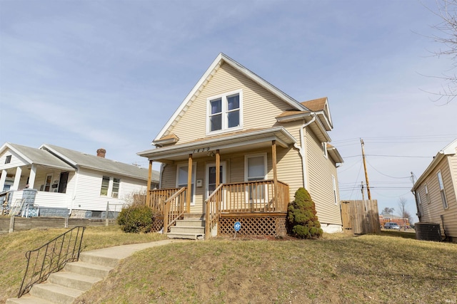 view of front of house featuring a porch, a front lawn, and central AC