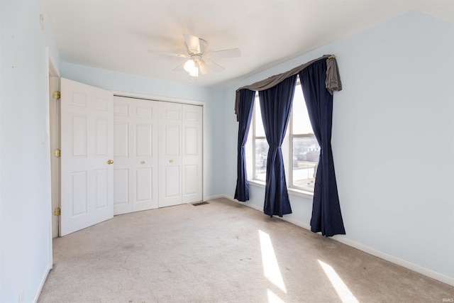 unfurnished bedroom with visible vents, baseboards, carpet, a closet, and a ceiling fan