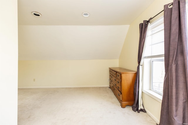 bonus room with vaulted ceiling, light colored carpet, baseboards, and a healthy amount of sunlight