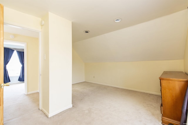 bonus room featuring baseboards, light carpet, and vaulted ceiling