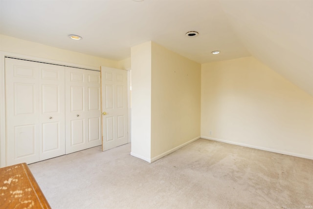 bonus room featuring lofted ceiling, light colored carpet, and baseboards