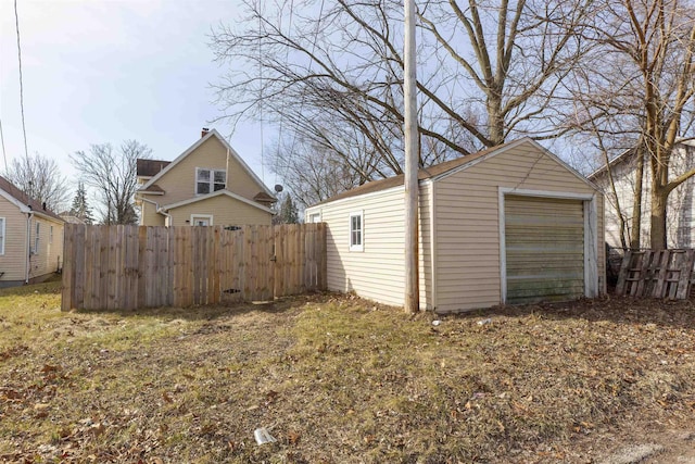 view of yard with a detached garage, an outdoor structure, and fence