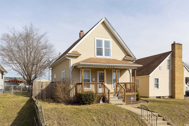 view of front of home with a front yard, a gate, fence, covered porch, and a chimney