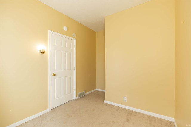 empty room with light carpet, visible vents, and baseboards