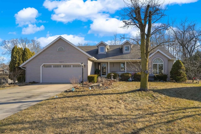 view of front facade with a front yard, covered porch, concrete driveway, and an attached garage