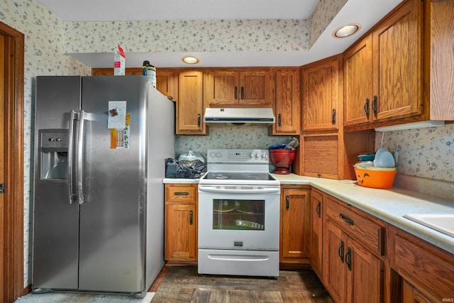 kitchen with electric range, light countertops, stainless steel refrigerator with ice dispenser, exhaust hood, and brown cabinets