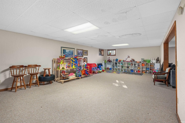 playroom with a drop ceiling, baseboards, and carpet