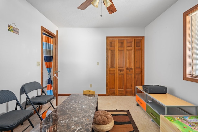 interior space with baseboards, a ceiling fan, and carpet flooring