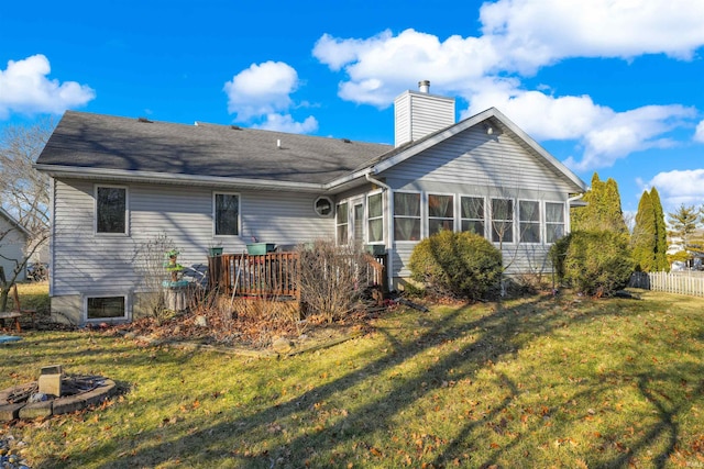 back of property with a yard, a chimney, and a sunroom