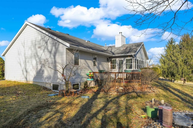 rear view of property with a wooden deck, a lawn, a chimney, and a sunroom