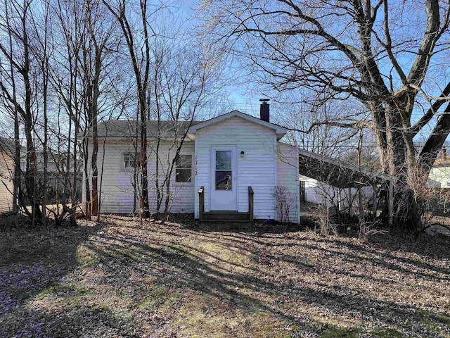 view of front of home with entry steps and a chimney