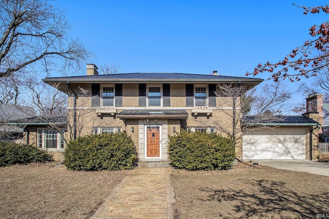 view of front of house featuring brick siding, a chimney, metal roof, a garage, and a standing seam roof