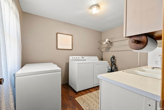 washroom with laundry area, dark wood-style floors, washing machine and dryer, and a sink