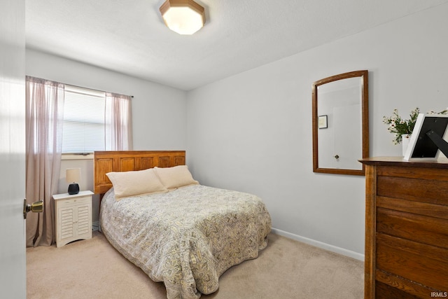 bedroom featuring baseboards and light colored carpet