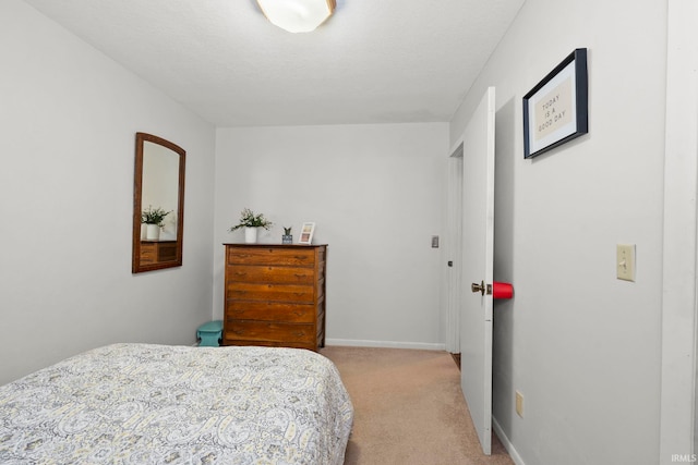 bedroom with baseboards and light carpet