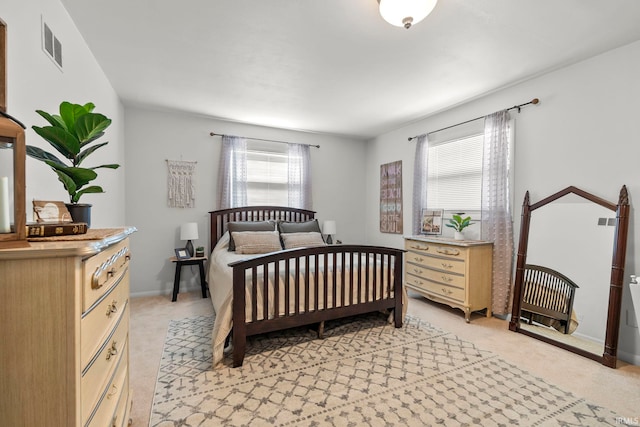 bedroom featuring visible vents, baseboards, and light colored carpet