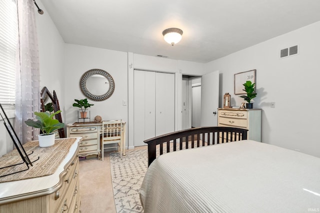 bedroom featuring light carpet, visible vents, and a closet