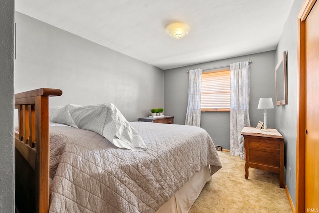 bedroom with light colored carpet and baseboards