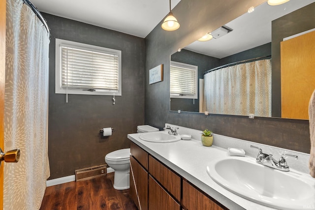 bathroom featuring a sink, visible vents, toilet, and wood finished floors