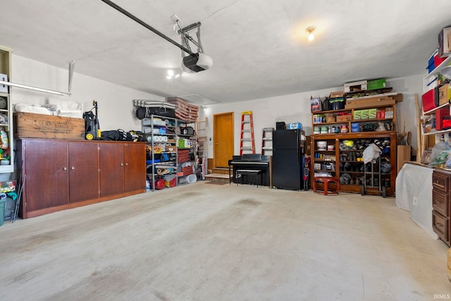 garage with a garage door opener and freestanding refrigerator