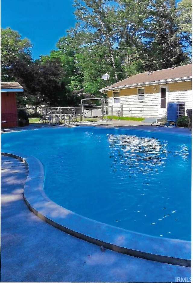 view of pool featuring a fenced in pool, central AC, and fence