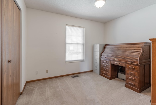 office area featuring visible vents, light colored carpet, a textured ceiling, and baseboards