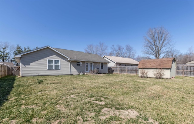 rear view of property featuring an outdoor structure, a storage unit, a fenced backyard, and a yard