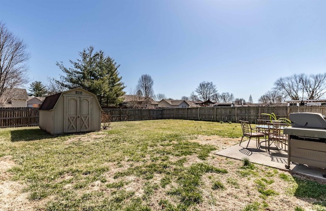 view of yard with a patio, a storage unit, a fenced backyard, and an outdoor structure