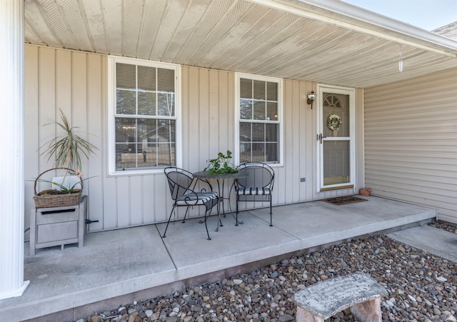 property entrance with board and batten siding and covered porch